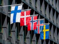 Fem nordiske flag blafrer i vinden på siden af en bygning